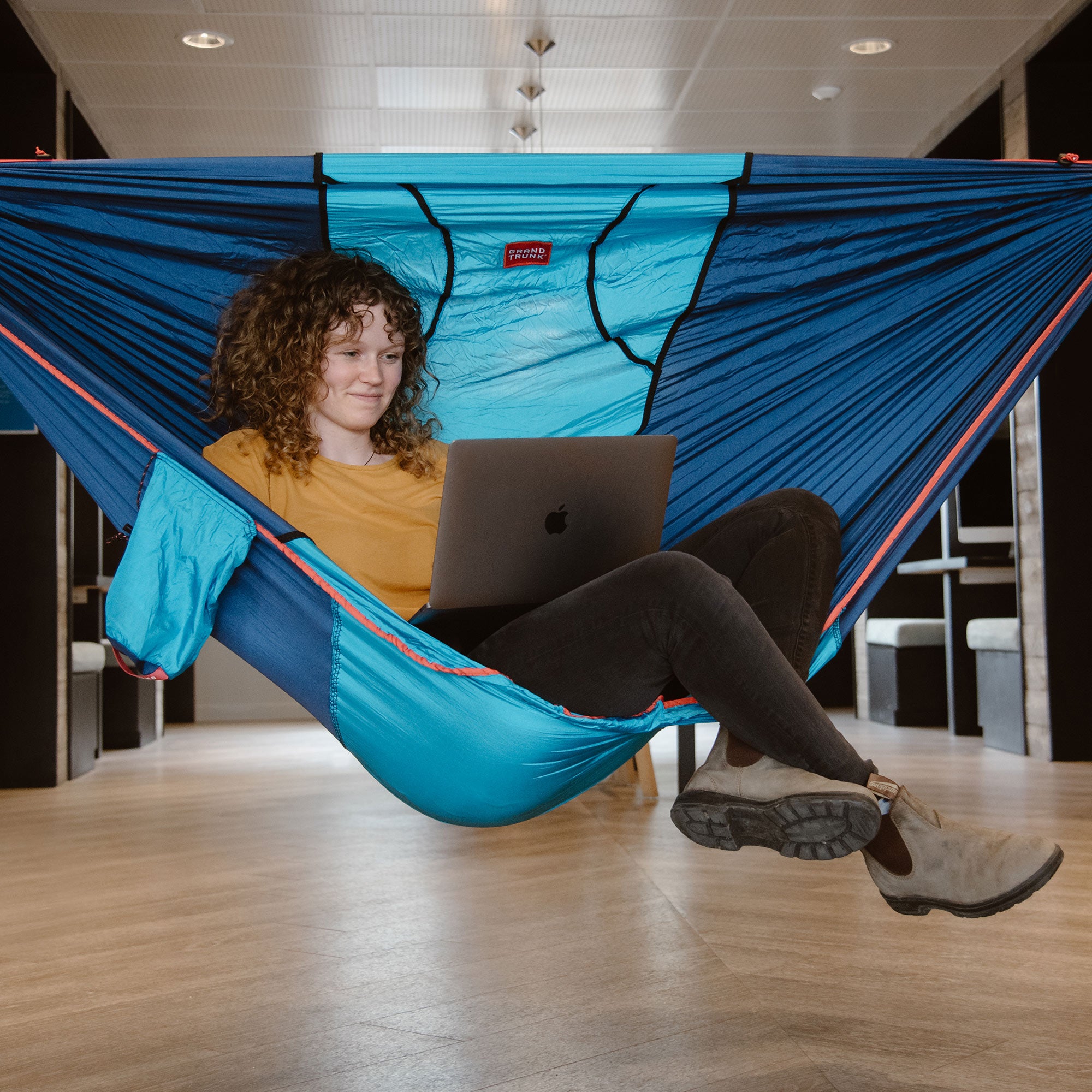 Woman sitting in ROVR while working on laptop indoors