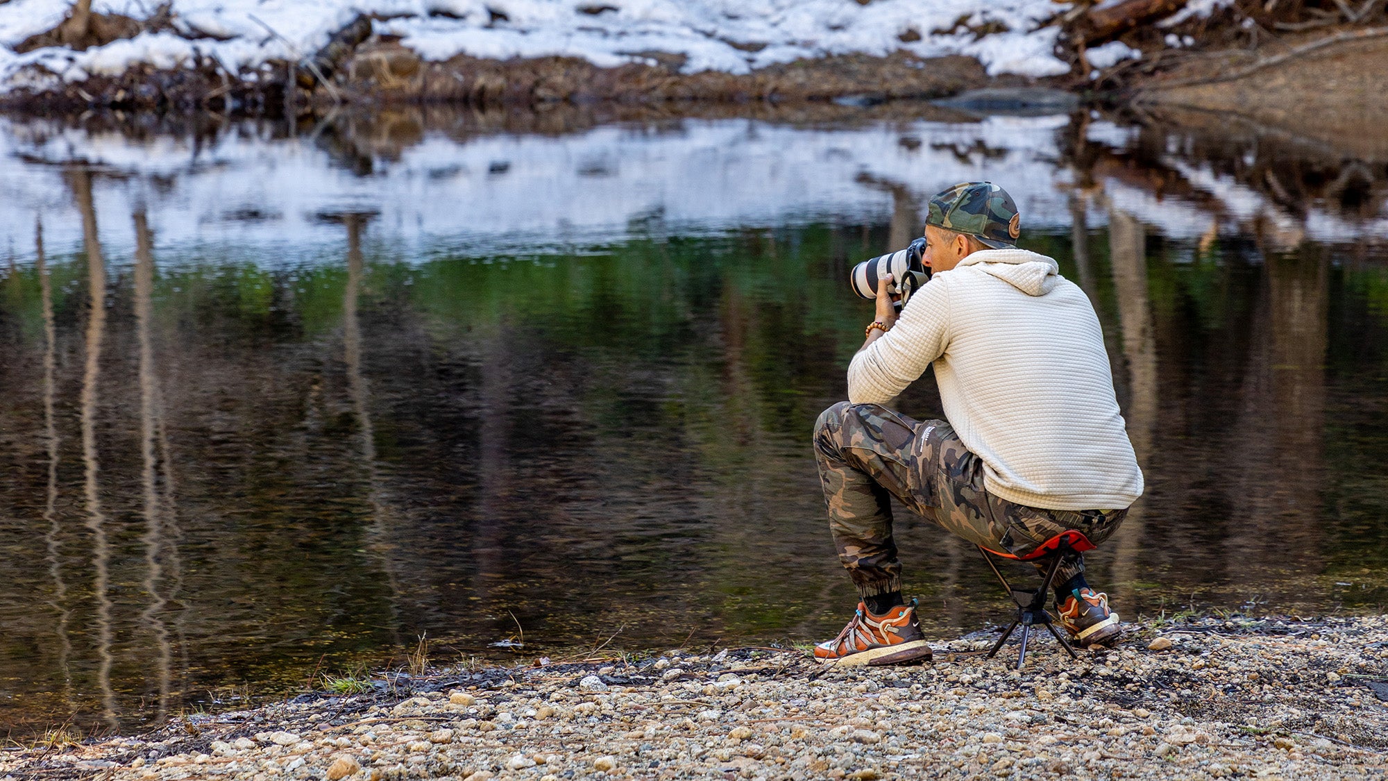 man takes photograph of wildlife using compass 360 stool
