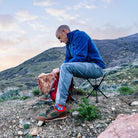 Man on stool n the mountains