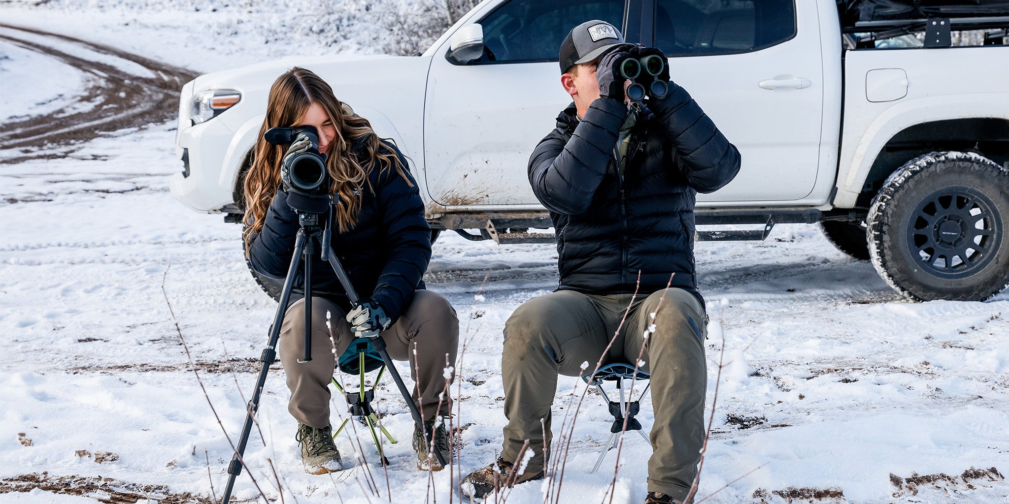 man and woman hunters glassing on compass 360 stool scope wildlife in mountains moose bear elk deer bull buck camoflauge